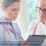 Two doctors discussing patient notes on a tablet - social media example